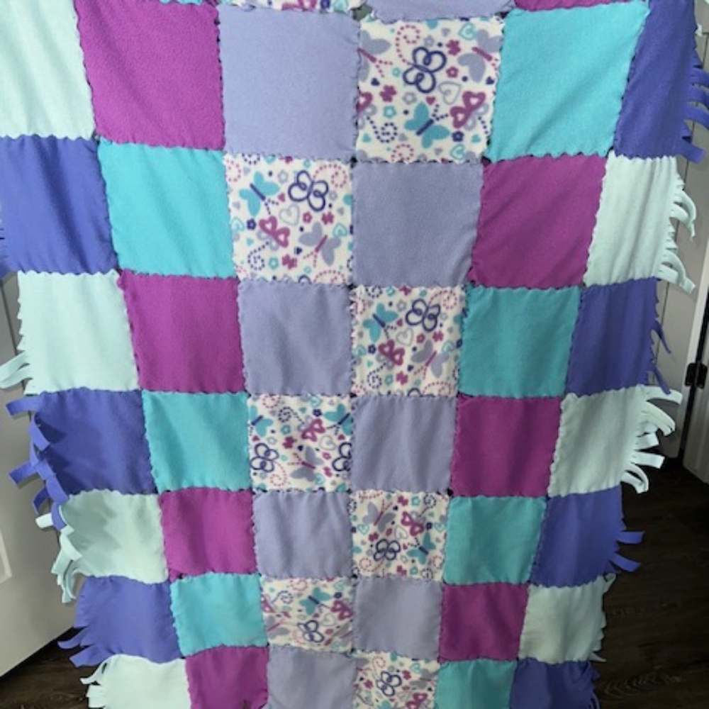 Fleece tie patchwork quilt throw blanket. Approximately 48" x 63"